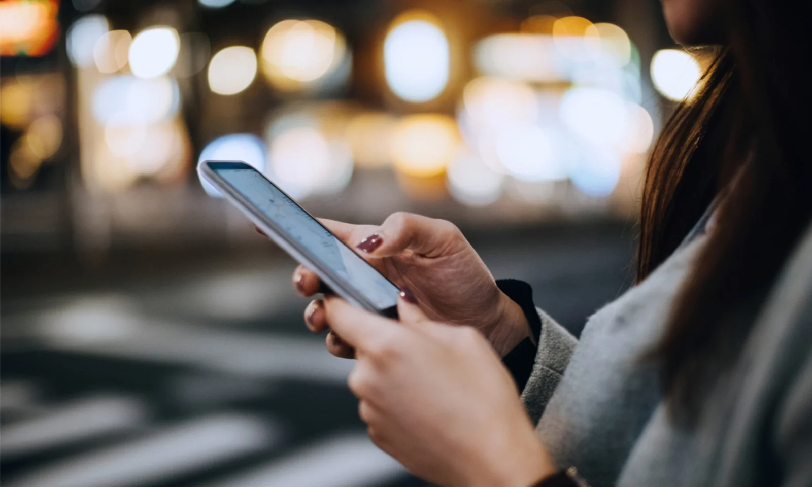 Erleben Sie die Zukunft des Bankings mit den mobilen Lösungen von Bankstart. Dieses Bild zeigt eine Nahaufnahme einer Person, die nachts ein Smartphone benutzt, mit einer verschwommenen Stadtlandschaft im Hintergrund. Entdecken Sie, wie die benutzerfreundliche mobile Banking-Plattform von Bankstart Komfort, Sicherheit und Effizienz bietet und es Ihnen ermöglicht, Ihre Finanzen mühelos auch unterwegs zu verwalten. Bleiben Sie mit der hochmodernen mobilen Banking-Technologie von Bankstart verbunden und behalten Sie die Kontrolle. gft-image-bankstart.jpg